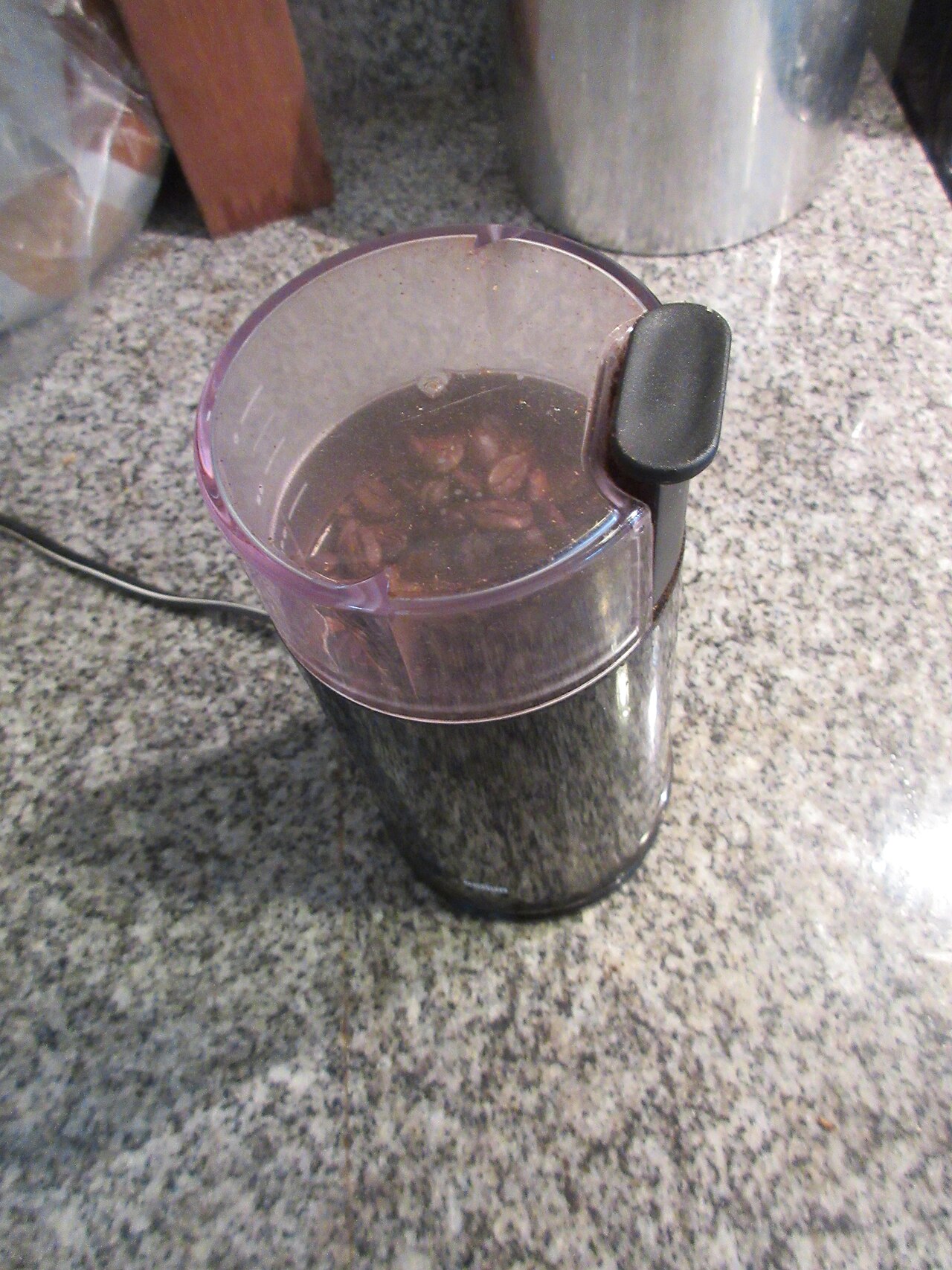 Close-up of a French press plunger descending into dark coffee, surrounded by steam